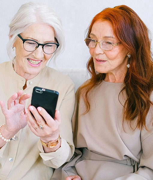 Two senior ladies looking at a mobile telephone