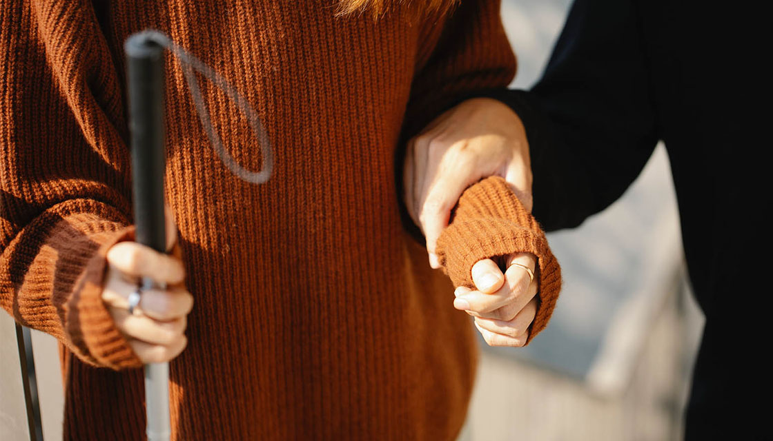 Friend holding blind person's arm